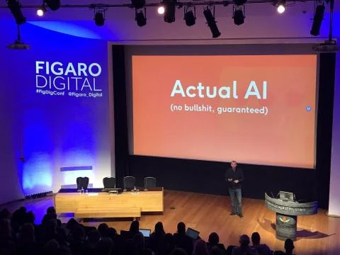 Parry Malm on stage at a Figaro Digital conference in front of a full auditorium, beside a screen reading Actual AI (no bullshit, guaranteed).